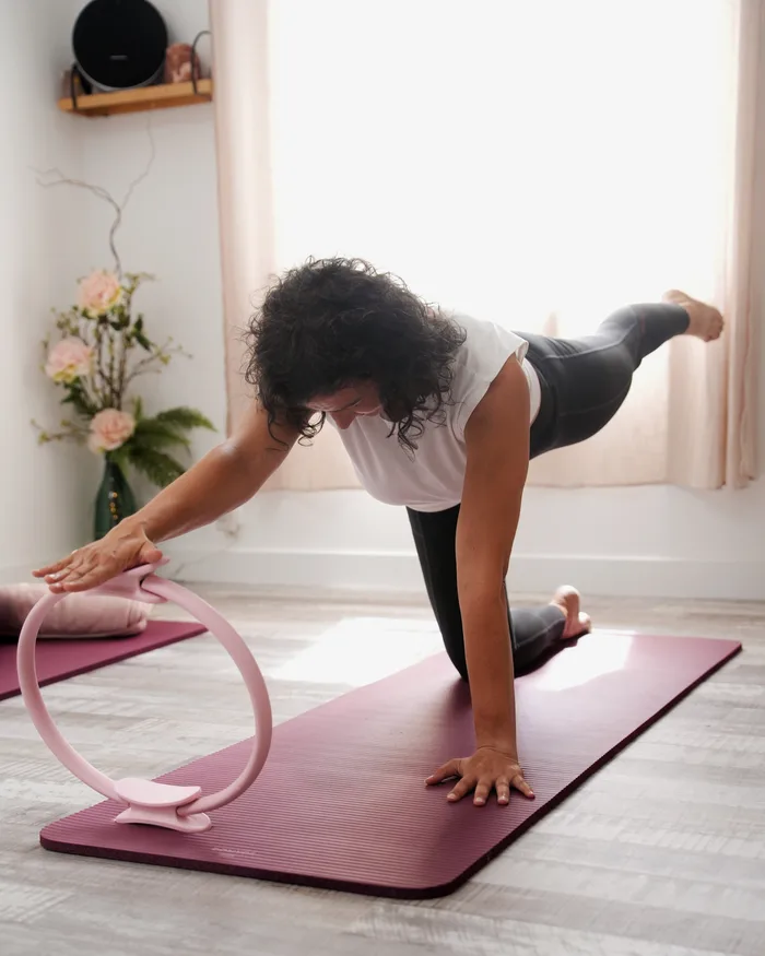 Exercice de Pilates à quatre pattes avec un cercle, sur tapis, au Well Studio de La Garde
