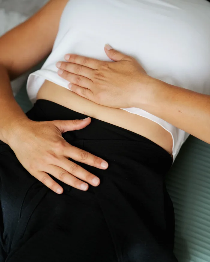 Mains posées sur le buste pendant une séance de Reiki, la personne reste habillée