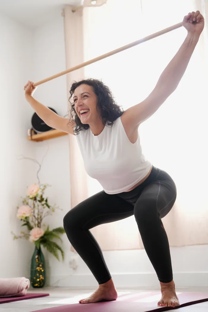 Squat avec barre au-dessus de la tête pendant un cours de renforcement musculaire au Well Studio de La Garde
